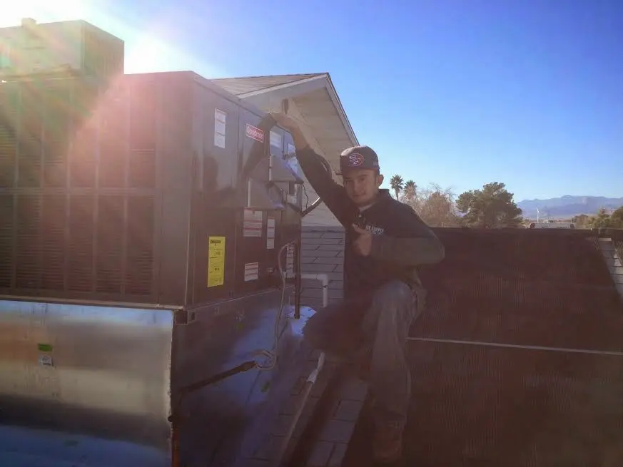 HVAC technician performing Boiler Repair on a rooftop unit in Apex